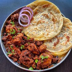 some food is sitting on a plate with onions and pita bread