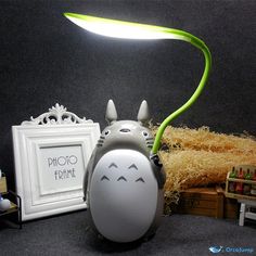 a lamp that is sitting on top of a table next to some pictures and toys