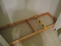 an unfinished bed frame sitting in the corner of a room with carpet on the floor