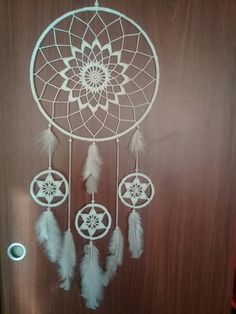 a white dream catcher hanging on a door