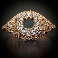 an antique diamond ring is shown on a black surface with the center surrounded by smaller diamonds