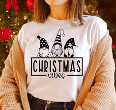 a woman standing in front of a christmas tree wearing a t - shirt with gnomes on it