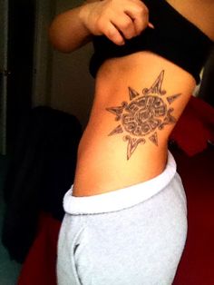 a woman with a sun tattoo on her stomach