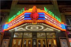 the entrance to a theater with neon lights