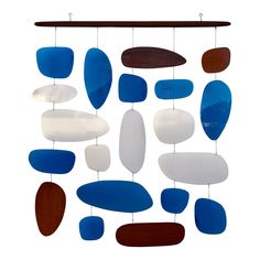 a wind chime with various shades of blue, brown and white glass hanging from it's side