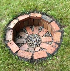 a fire pit made out of bricks in the grass