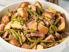 a white bowl filled with potatoes and green beans