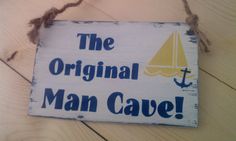 a wooden sign that says the original man cave with a sailboat and anchor on it