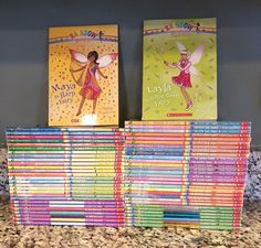 several children's books are stacked on top of each other in front of a granite countertop