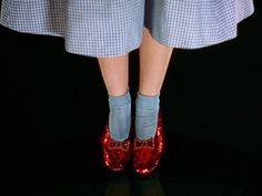 the legs of a woman wearing red shoes