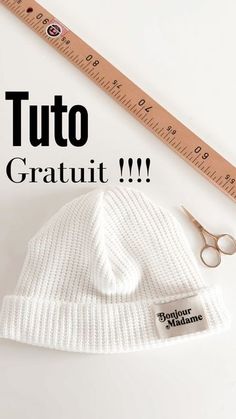 a white hat and pair of scissors next to a ruler with the words tuto gratut on it