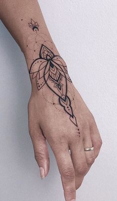 a woman's hand with a small tattoo on the left side of her arm