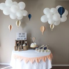 a table topped with lots of balloons and desserts