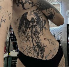 a woman with tattoos on her stomach in a bathroom