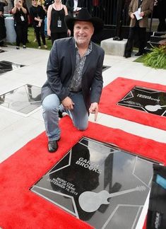 a man kneeling on top of a red carpet