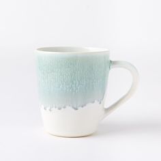 a white and green coffee cup with blue streaks