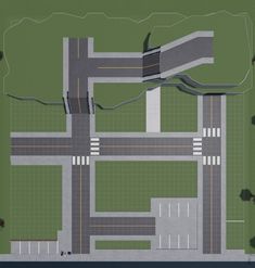 an aerial view of a street intersection in the middle of a green area with trees