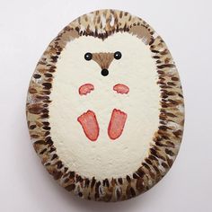 a painted rock with an animal face on it's side and feet in the middle