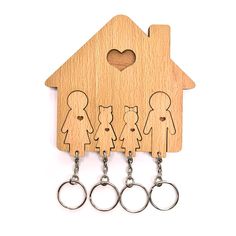 a wooden keychain with three people and a house cutout on it's side