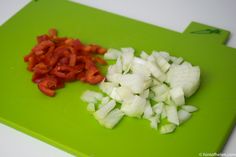 chopped onions and tomatoes on a green cutting board