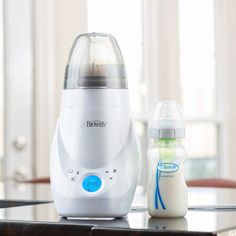 a baby bottle sitting on top of a table next to a blender and bottle