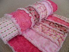 several pieces of pink and white fabric stacked on top of each other in the floor