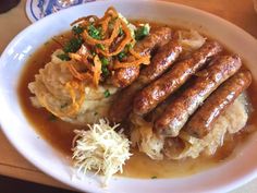 a white plate topped with sausage and mashed potatoes