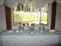 a table with desserts and cupcakes on it in front of a window