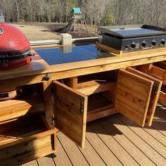 an outdoor bbq table with grill and storage drawers on the back deck is shown