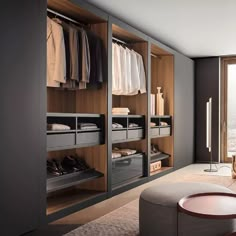 a walk in closet filled with lots of clothes next to a sliding glass door window