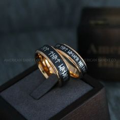 two gold rings with black lettering on them