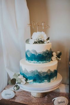 a blue and white wedding cake sitting on top of a table