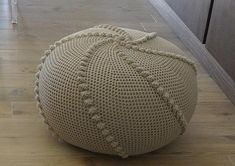 a crocheted poufce sits on the floor in front of a door