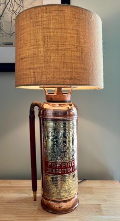 a lamp that is sitting on top of a wooden table next to a framed photograph