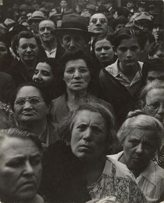 an old black and white photo of many people in the crowd looking up at something