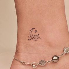 a woman's foot with a small tattoo on the side of her leg and a chain attached to it