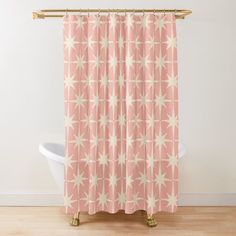 a pink shower curtain with white stars on it and a gold metal rod in the corner