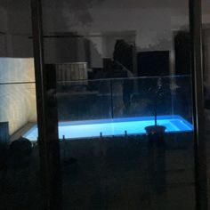 an indoor swimming pool in the middle of a dark room with no people around it