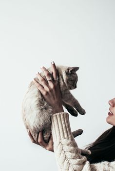 a woman holding a cat up to her face