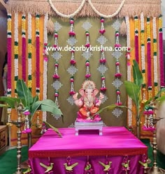 an elephant statue sitting on top of a table in front of a wall with decorations