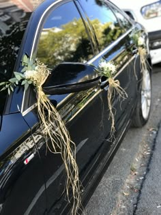 a black car decorated with flowers and greenery