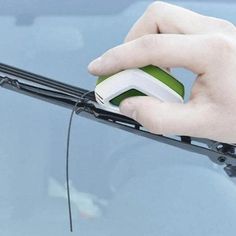 a hand with a mouse on top of a car door handle and windshield wiper