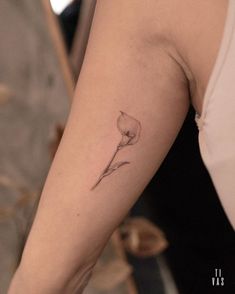 a woman's arm with a single flower tattoo on the left side of her arm