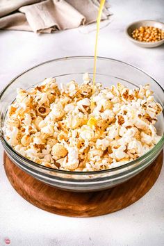 a glass bowl filled with popcorn sitting on top of a table