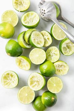 limes are cut in half and placed next to a spoon