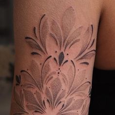 a woman's arm with a flower tattoo design on the left side of her body