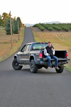 a man sitting on the back of a pickup truck