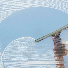 the reflection of a person holding an umbrella in water with white lines drawn on it