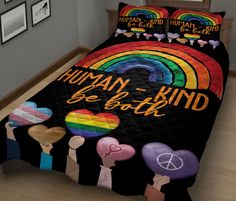 a bed covered in a black comforter with rainbows and hearts