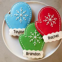 three decorated cookies on a plate with name tags